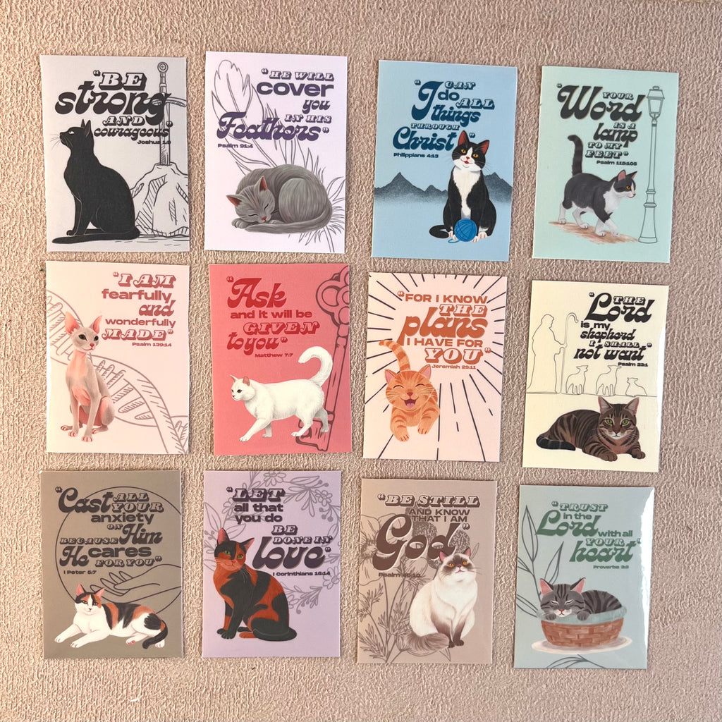 Collection of stickers with cat illustrations and motivational quotes on a textured surface.