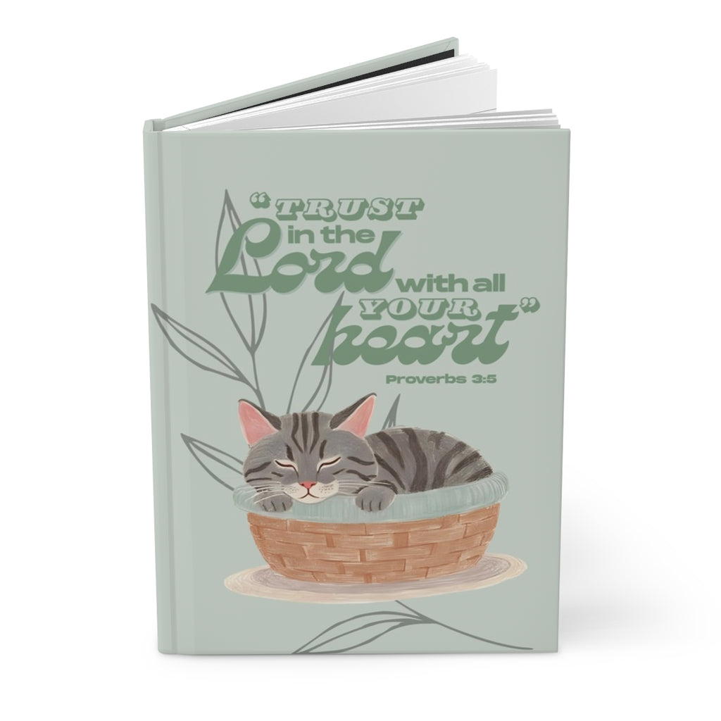 Book with a cat illustration and motivational quote on a light green background