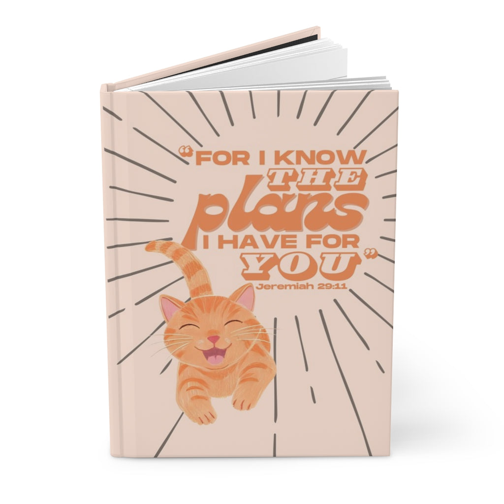 Notebook with a cat illustration and motivational quote on a white background