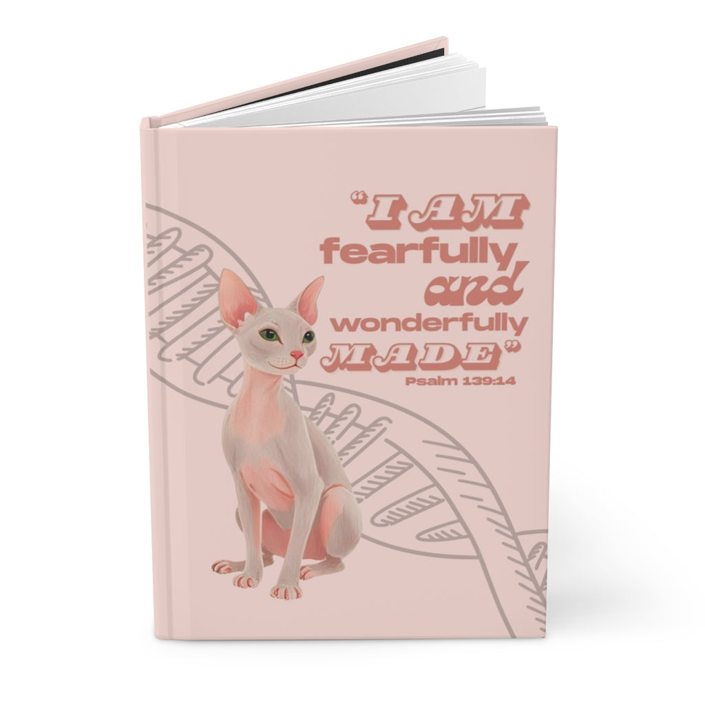 Notebook with a cat illustration and text on a pink background