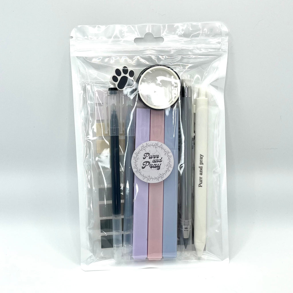 Stationery set packaged in a clear bag including pens, highlighters, sticky notes, washi tape, bookmark, and eraser for Christian journaling arranged neatly in gray color palette.
