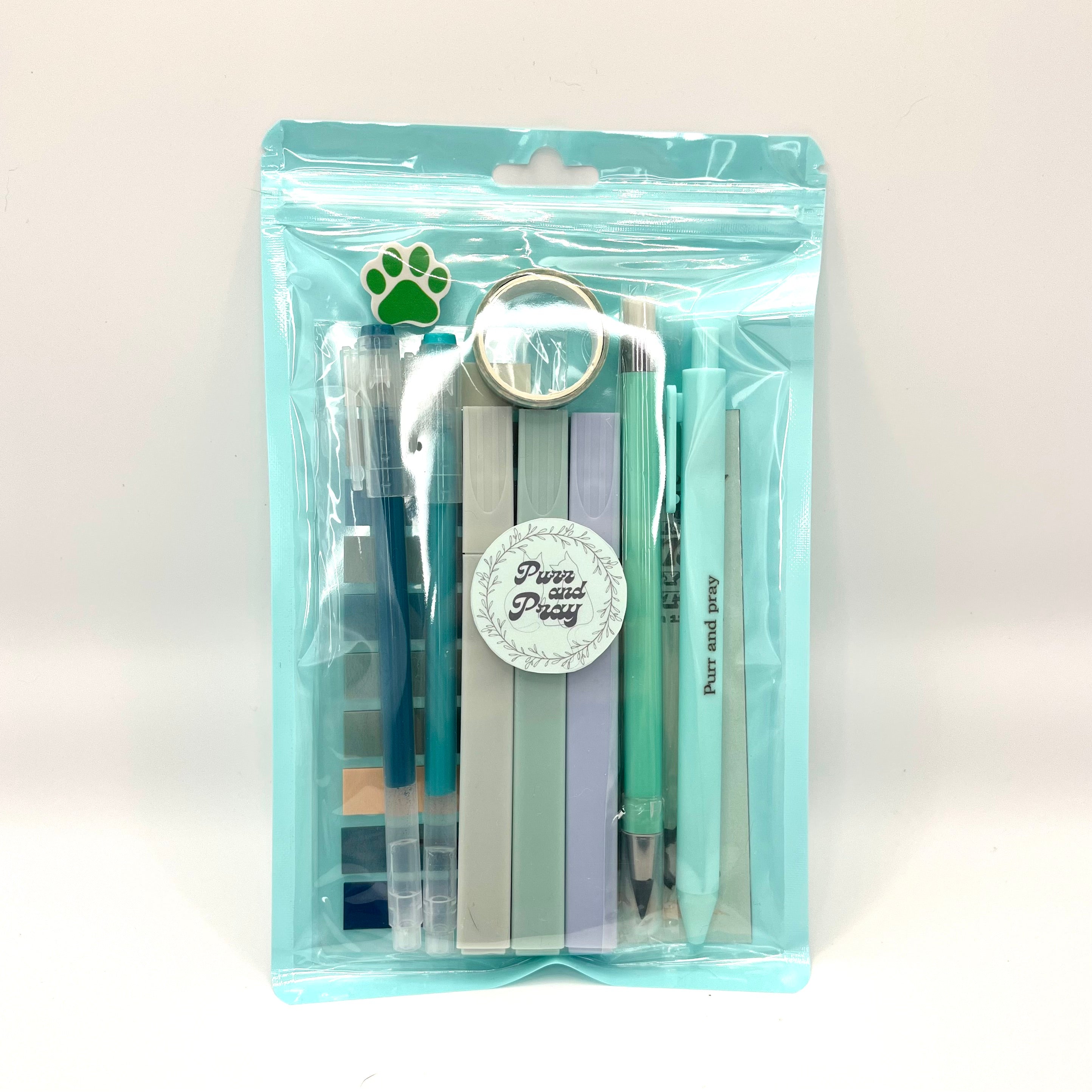 Stationery set packaged in a clear bag including pens, highlighters, sticky notes, washi tape, bookmark, and eraser for Christian journaling arranged neatly in mint color palette.