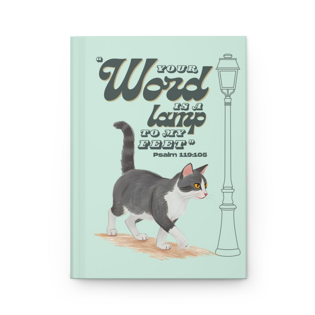 Front cover of A5 Christian journal featuring the Bible verse ‘Your word is a lamp to my feet’ with a gray tuxedo cat illustration.