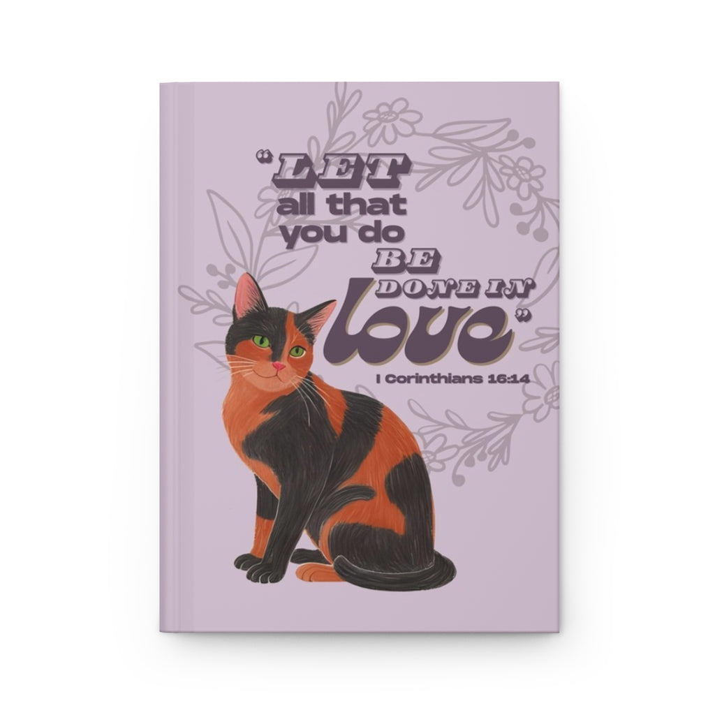 Front cover of A5 Christian journal featuring the Bible verse ‘Let all that you do be done in love’ with a tortoiseshell cat illustration.