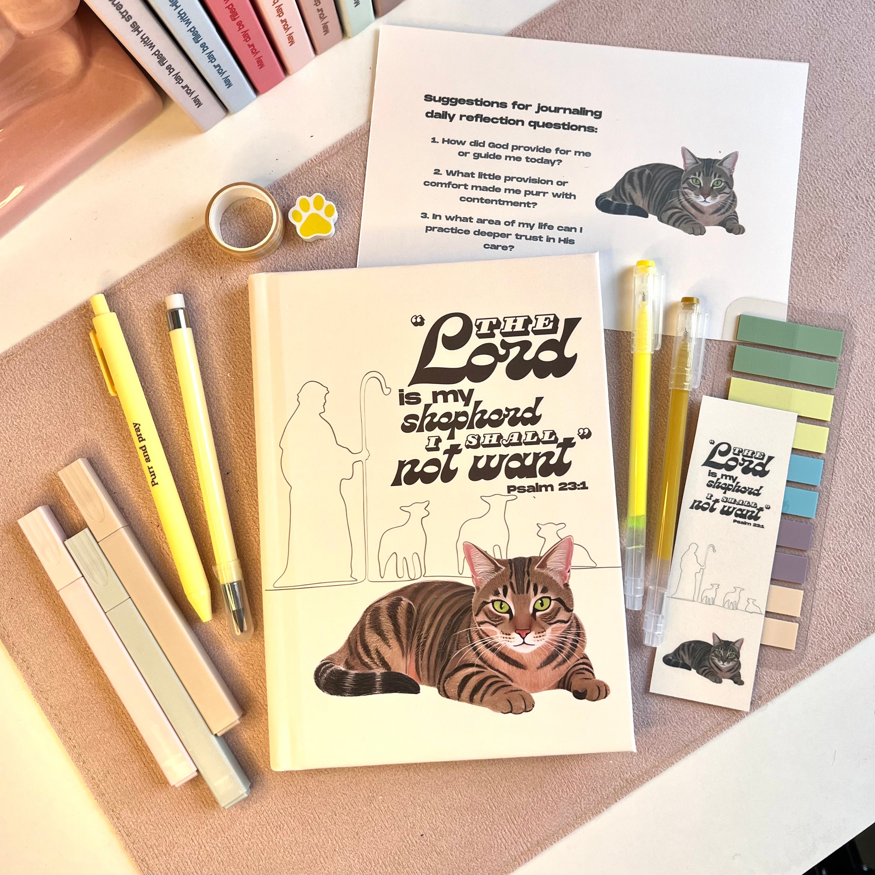 Cat-themed stationery set with pens, stickers, and a card on a textured surface