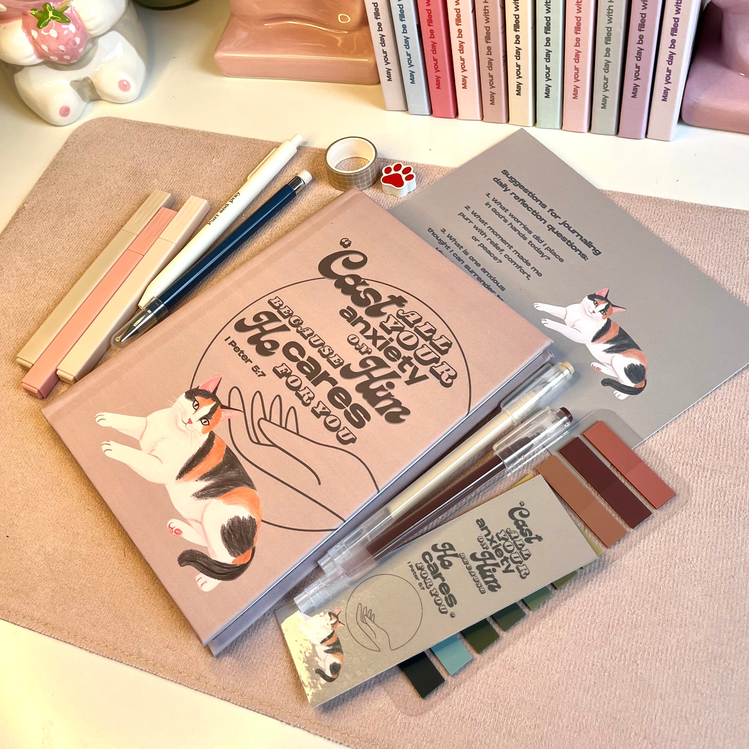 Notebook with calico cat illustrations and stationery items on a desk