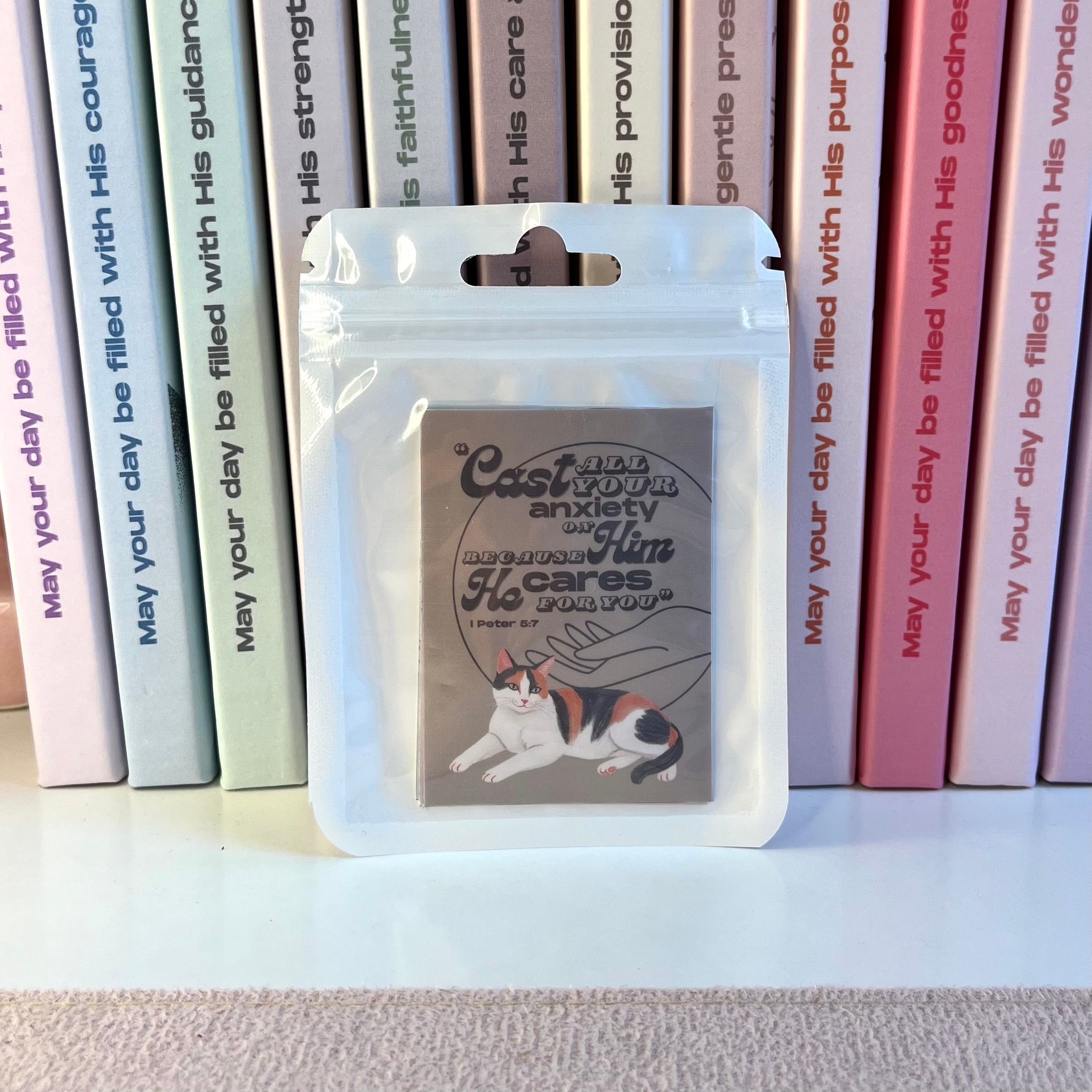 Packaged stickers with a cat illustration in front of books with motivational text.
