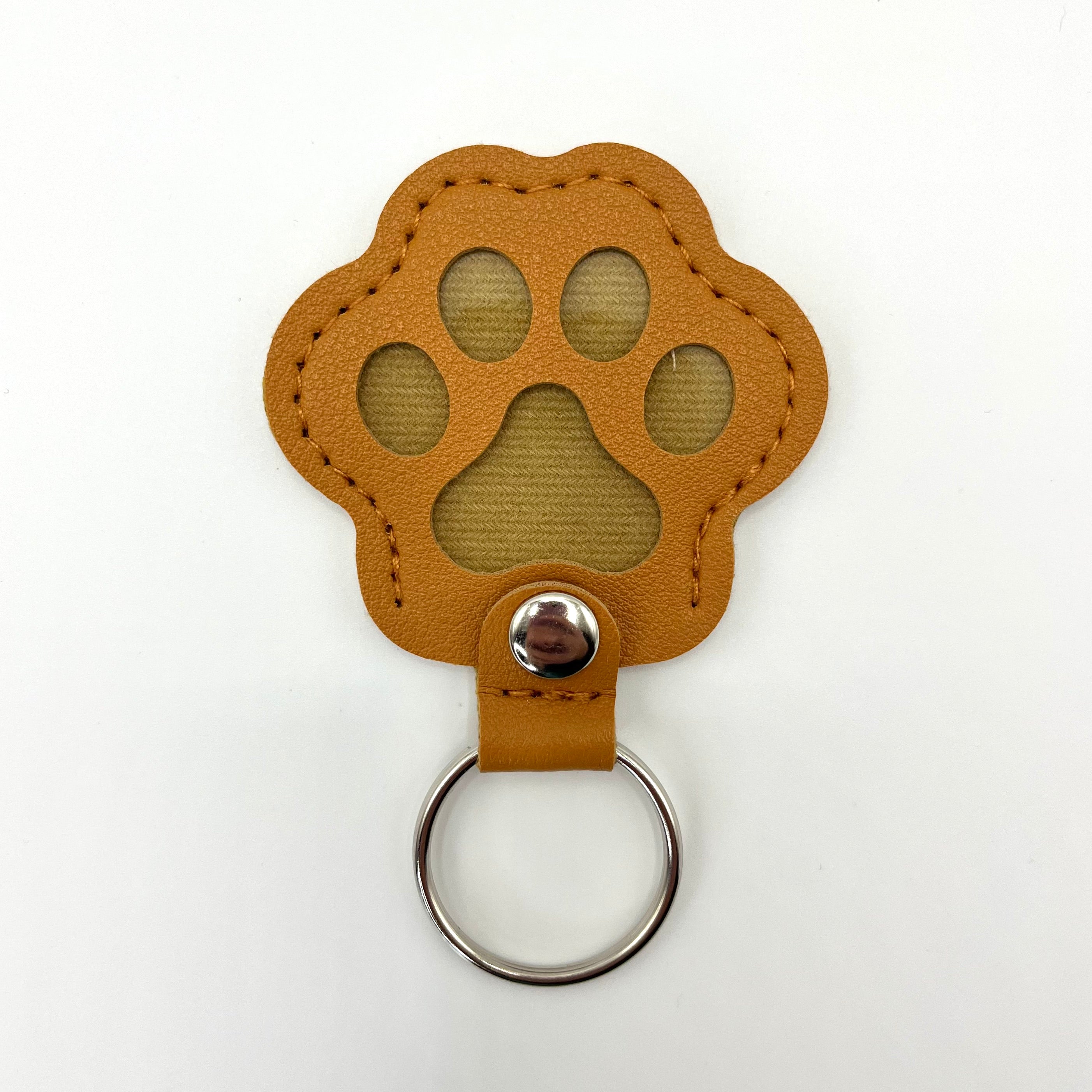 Caramel faux leather paw-shaped keepsake keychain with metal ring – pet memorial gift.