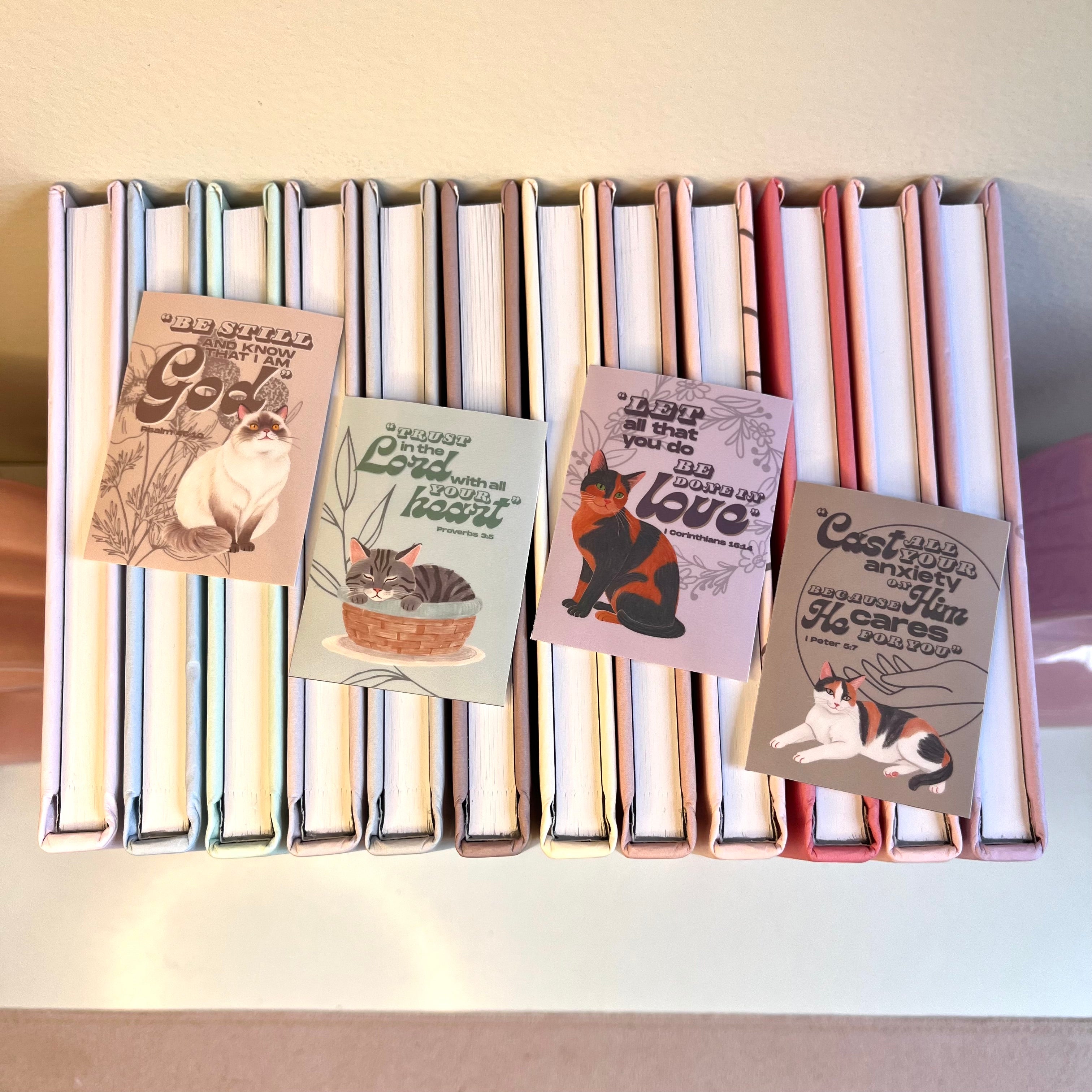 Stack of books with cat-themed stickers on a white surface