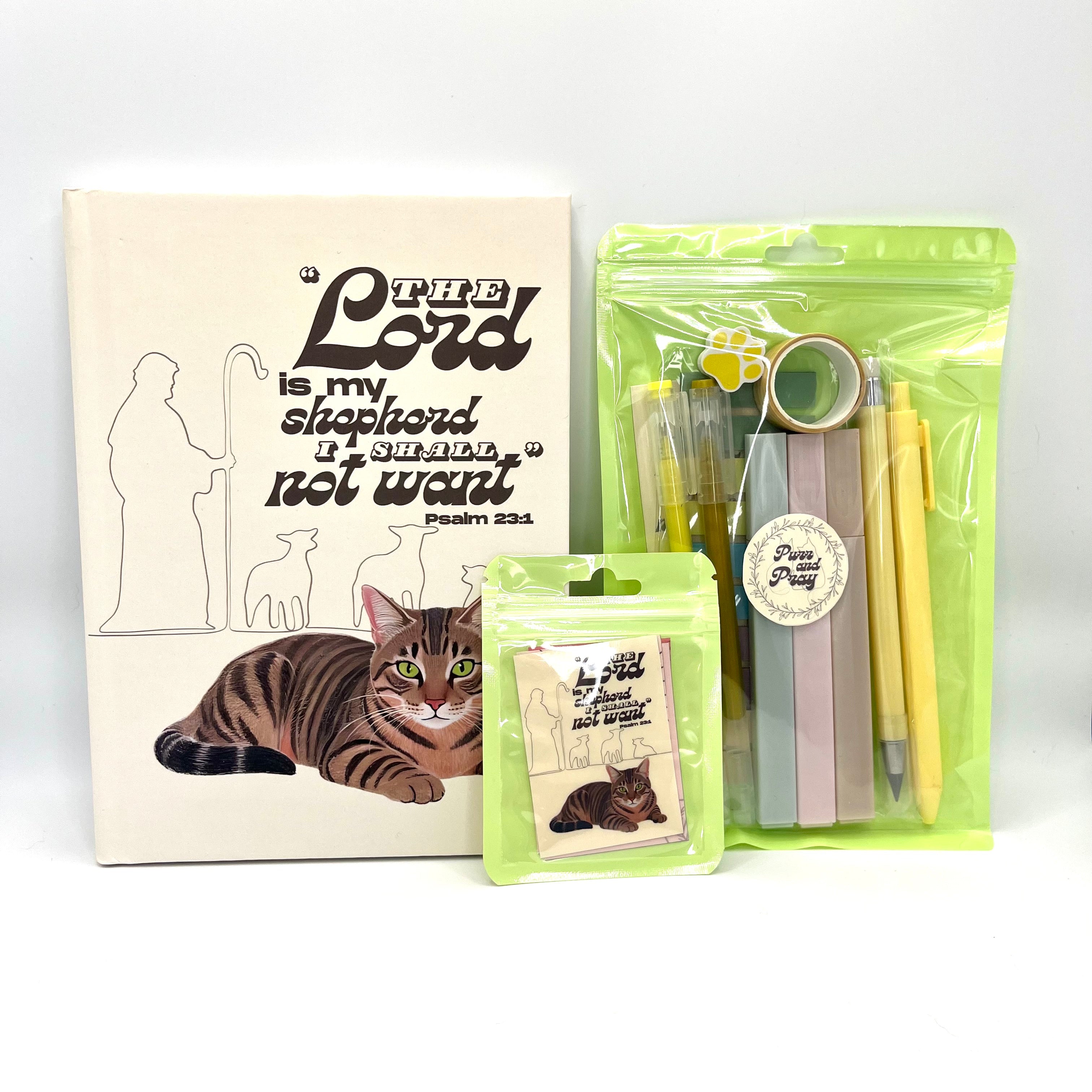 Packaged Christian gift set including a Bible verse journal with a brown tabby cat artwork, stationery items in clear bags, and Scripture sticker pack.