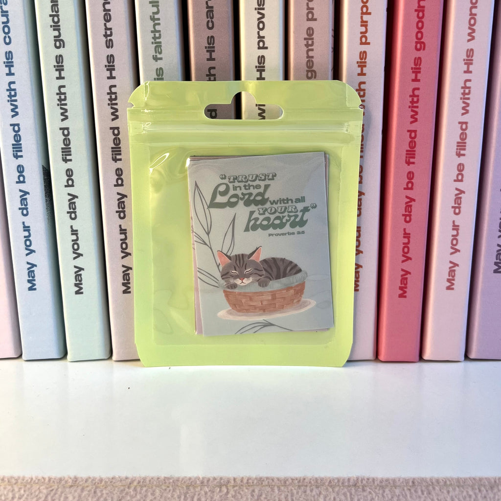Packaged stickers with a cat illustration in front of books with motivational text.