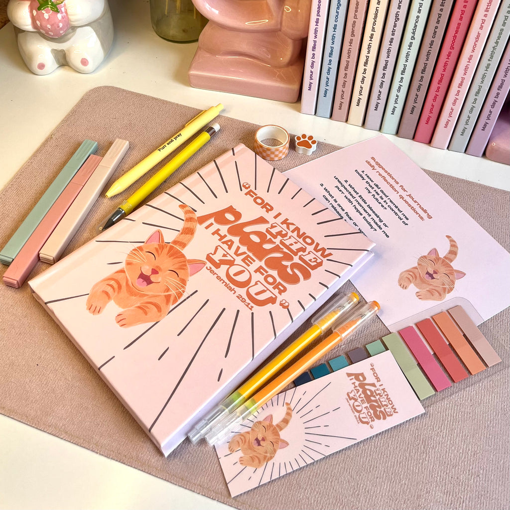 Stationery items with orange cat illustrations on a desk