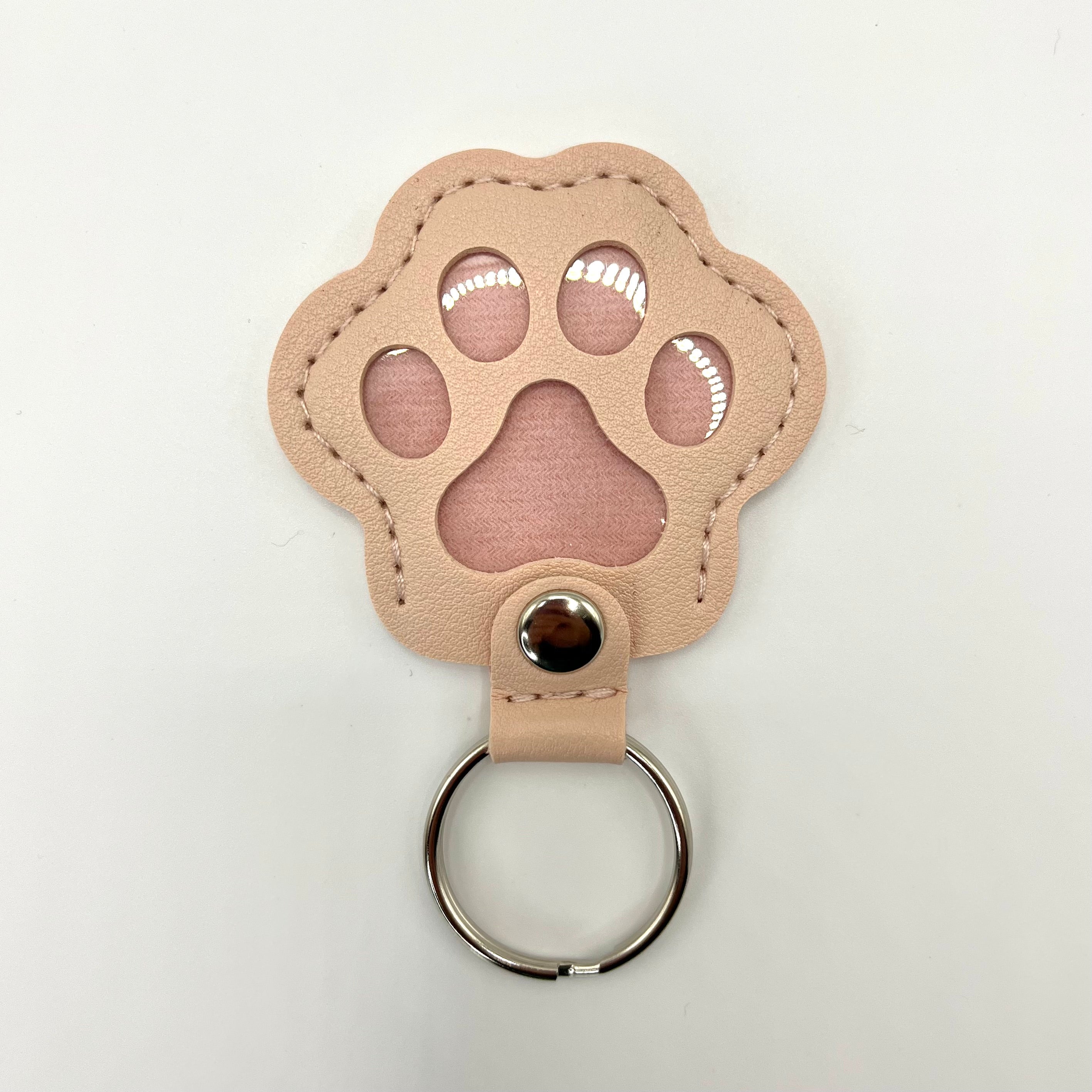Pink faux leather paw-shaped keepsake keychain with metal ring – pet memorial gift.