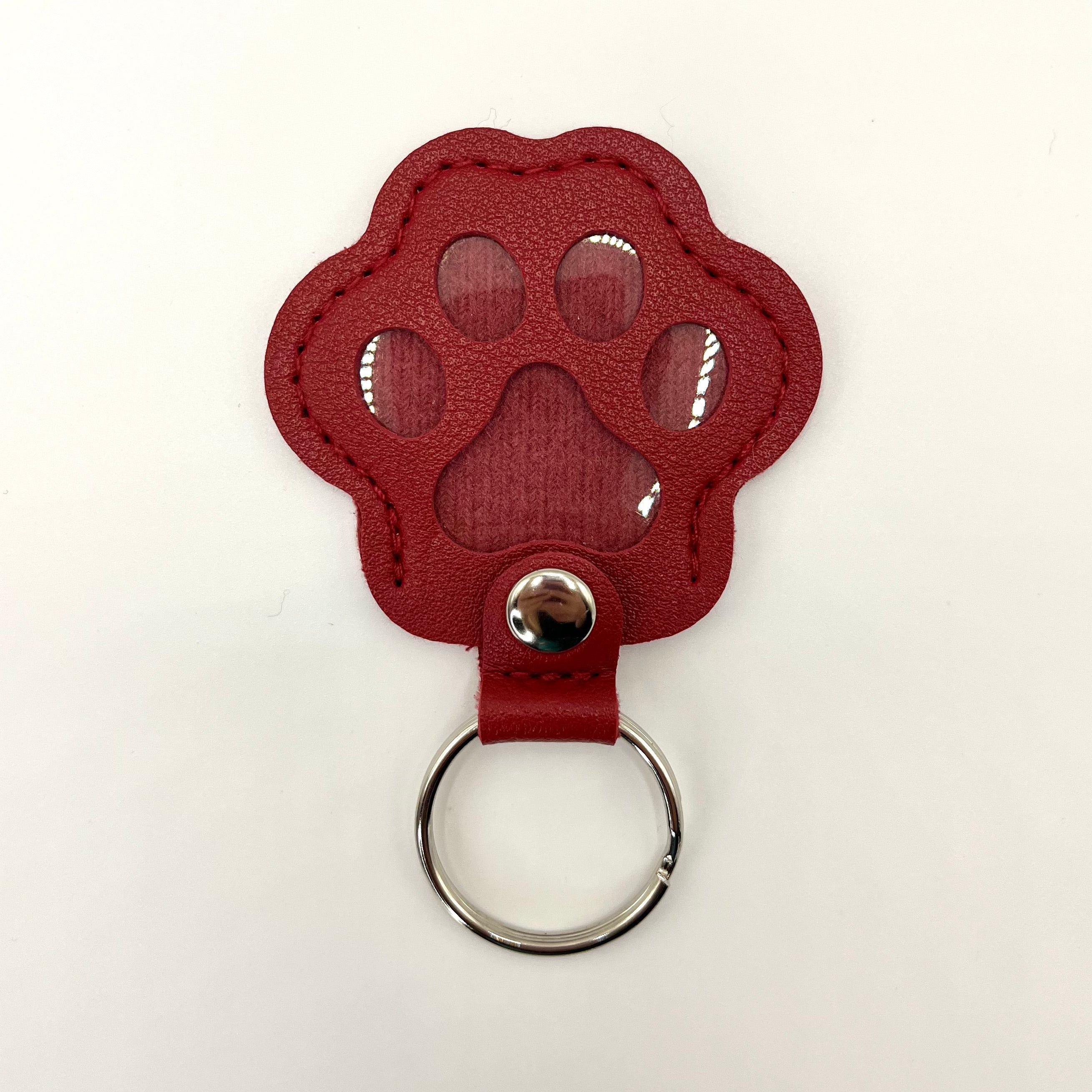 Red faux leather paw-shaped keepsake keychain with metal ring – pet memorial gift.