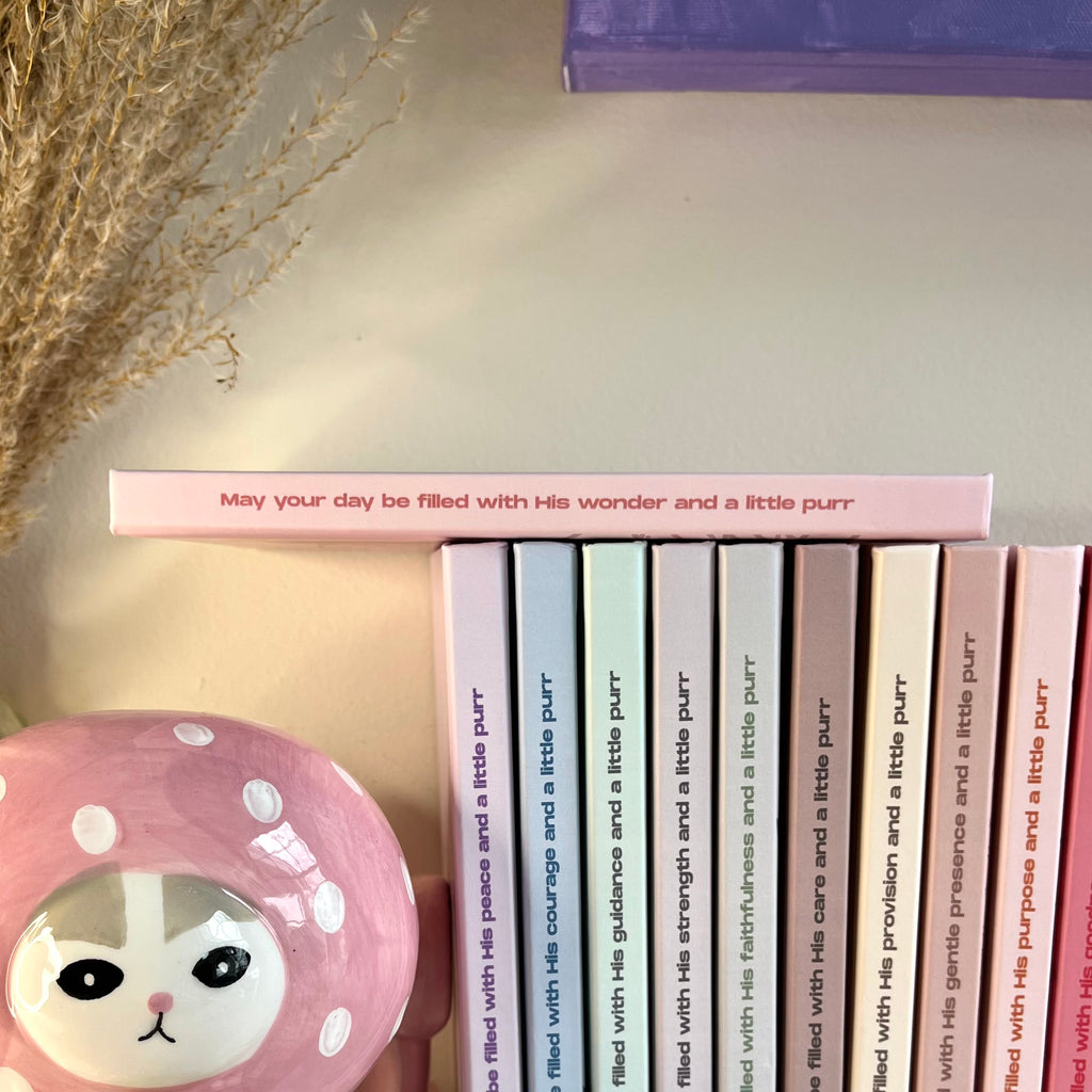 Side of a pink notebook with a christian text on it