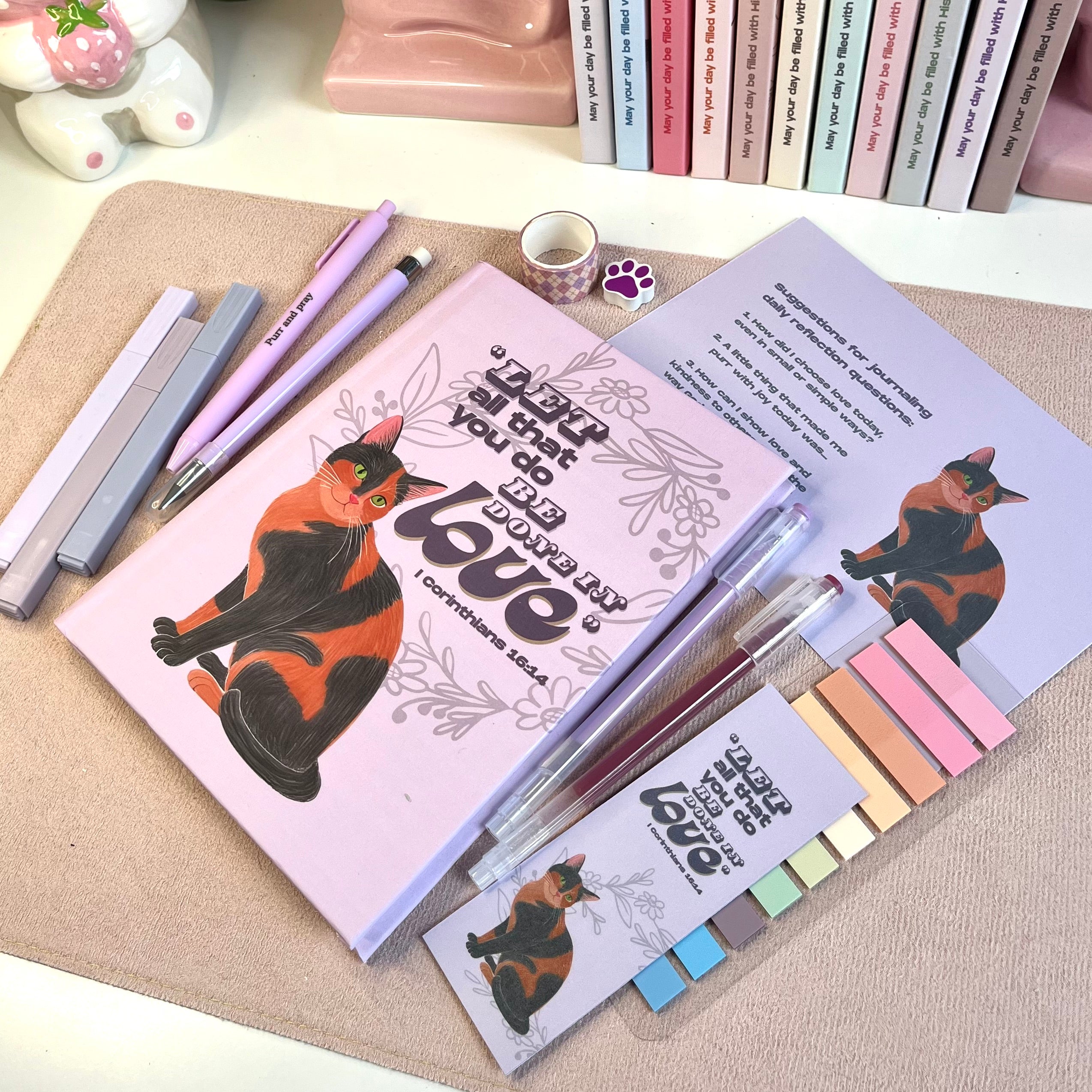 Notebooks with cat illustrations and stationery items on a textured surface