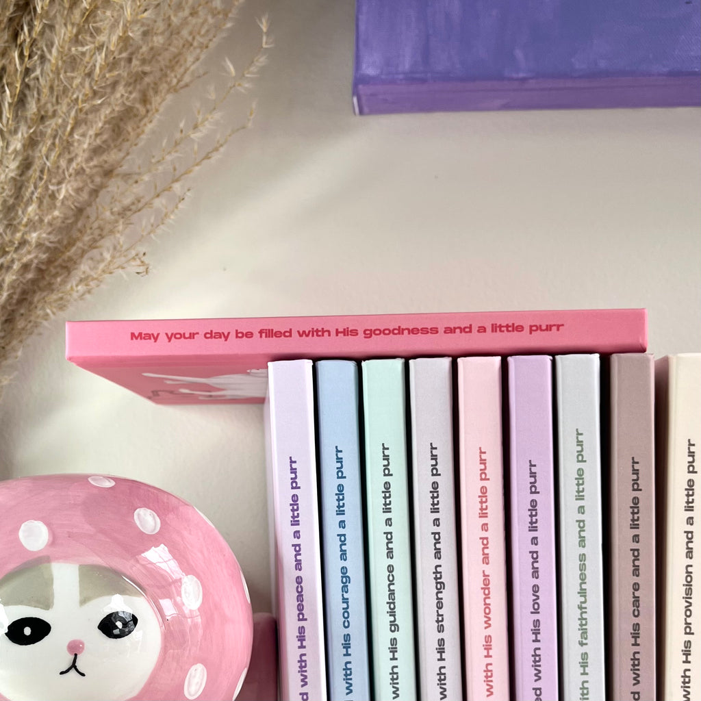 Side of a pink notebook with a Christian text on it.